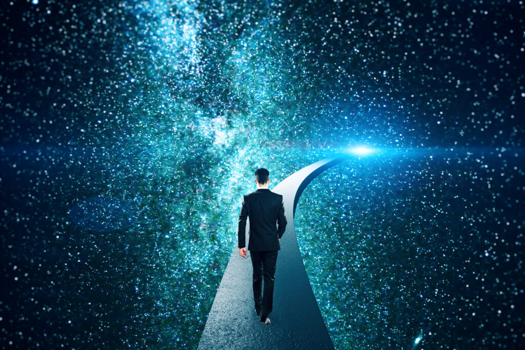 A man walking on a path under a sky full of stars